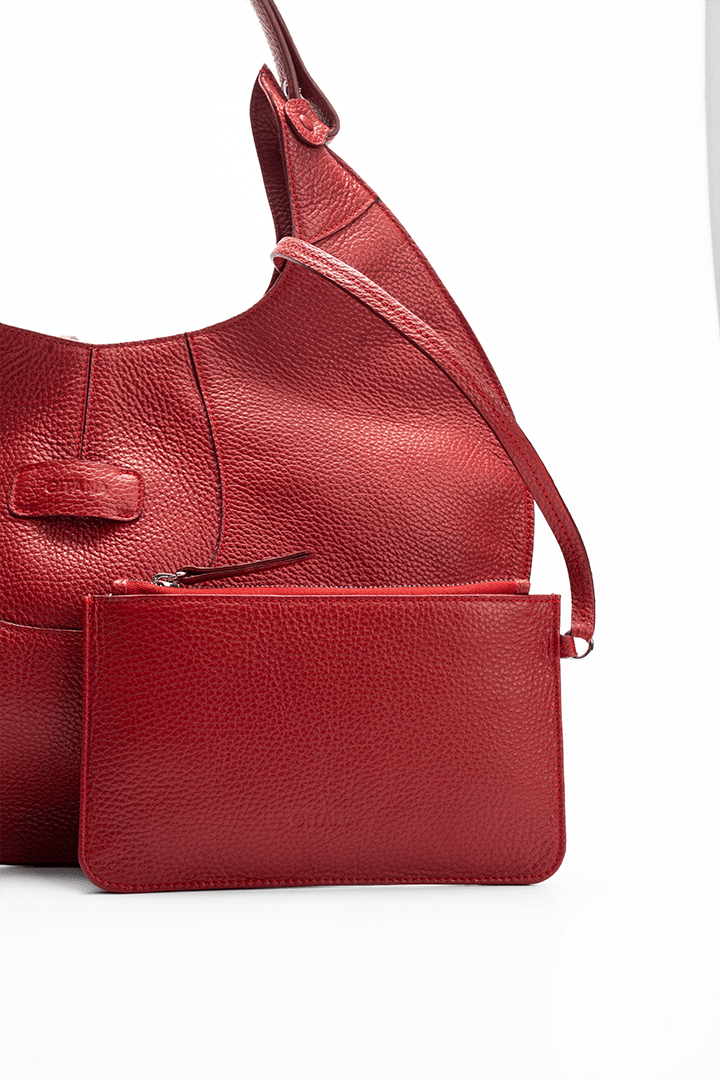 Close-up front view of a red luxury pebble calf tote bag with a matching small pouch attached by a strap, displayed on a white background.