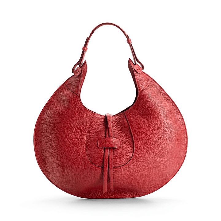 A red designer luxury pebble calf tote bag, showcasing the curved designer silhouette against a white background.