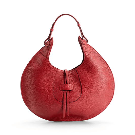 A red designer luxury pebble calf tote bag, showcasing the curved designer silhouette against a white background.