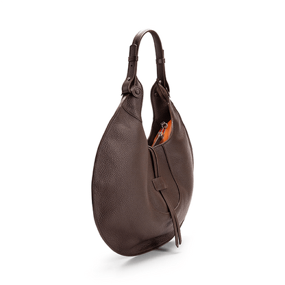 The side view of a brown luxury designer pebble calf tote bag, showcasing the curved designer silhouette against a white background.