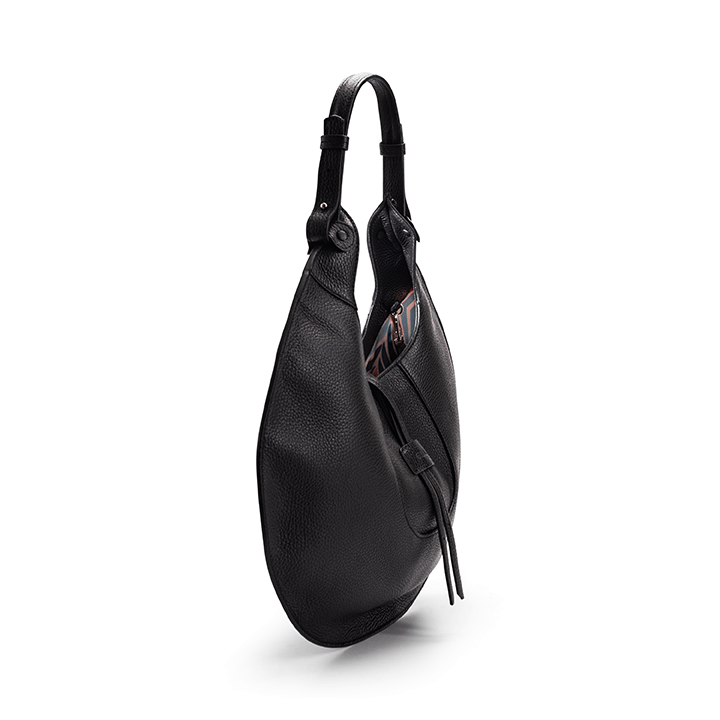 The side view of a black luxury designer pebble calf tote bag, showcasing the curved designer silhouette against a white background.
