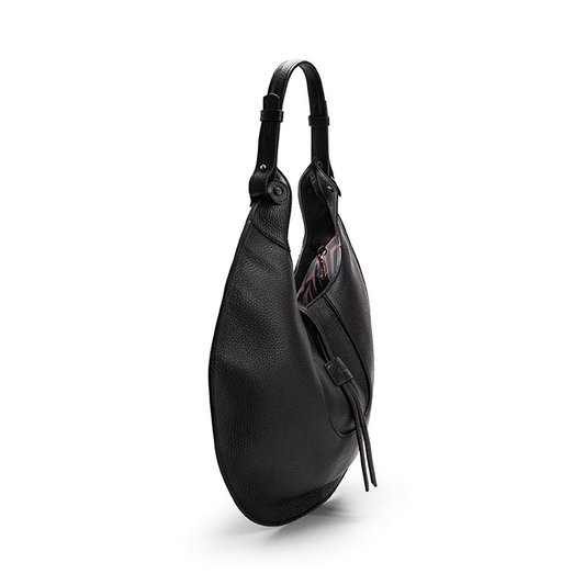 The side view of a black luxury designer pebble calf tote bag, showcasing the curved designer silhouette against a white background.