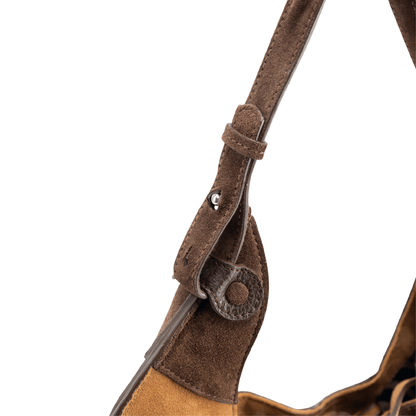 Close-up of a shoulder strap on a designer luxury chocolate brown suede tote bag.