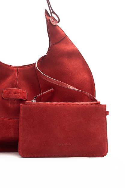 Close-up front view of a scarlet luxury suede tote bag with a matching small pouch attached by a strap, displayed on a white background.