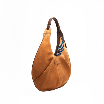 Side view of a large caramel luxury suede tote handbag on a white background.