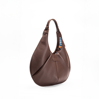 Side view of a large brown luxury Italian pebble calf leather tote handbag on a white background.