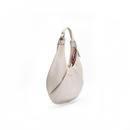 Side view of a large beige luxury Italian pebble calf tote handbag on a white background.