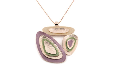 Long rose gold chain necklace with sculptural layered pendant in mauve, sage green and metallic tones on white background