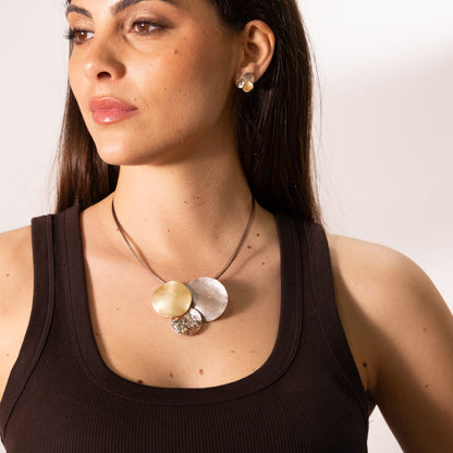 Model wearing short Zamak necklace with three round pendants in rose gold, taupe and champagne enamel