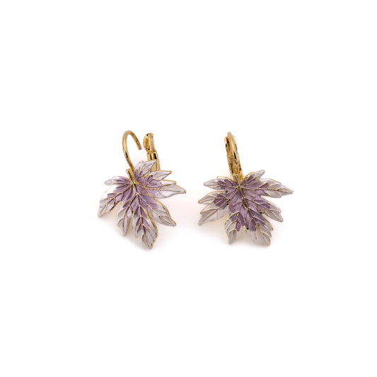 A delicately detailed maple leaf, hand-enamelled in soft lilac and ivory, dangles from a lever-back hook in warm yellow gold against a white background.