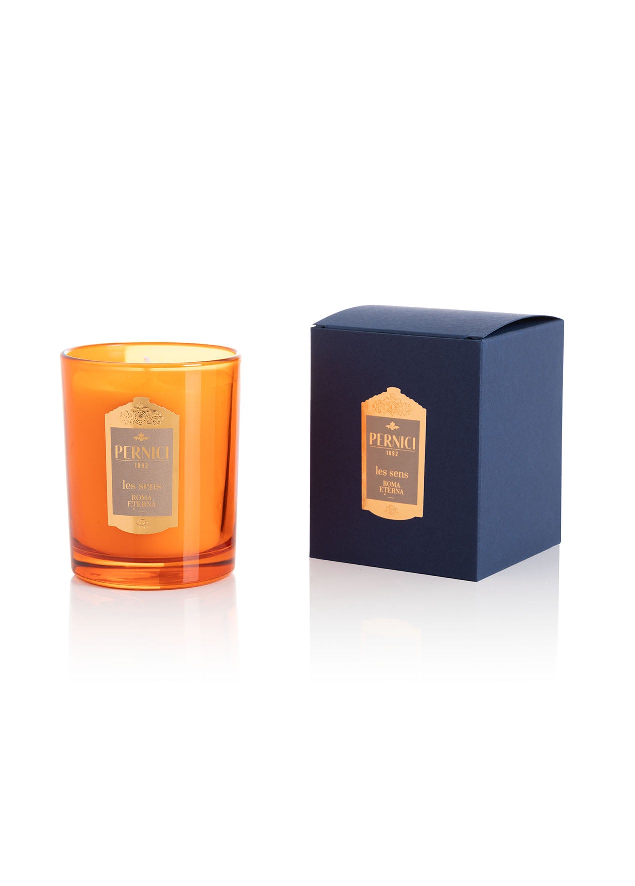 Cereria Pernici Les Sens Roma Eterna 70g scented candle in a deep amber glass tumbler with gold Pernici 1892 label, shown alongside its navy blue gift box with gold foil label, product shot on white background