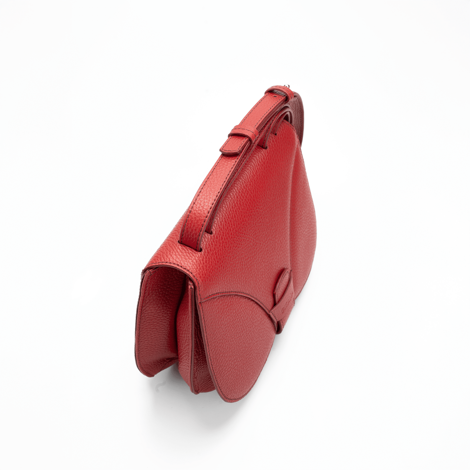 The red Italian pebbled calf leather crossbody handbag seen from above, focusing on the adjustable handle.