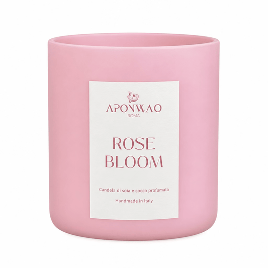A pink glass jar candle with a white rectangular label reading 'APONWAO ROMA ROSE BLOOM' on a plain white background.