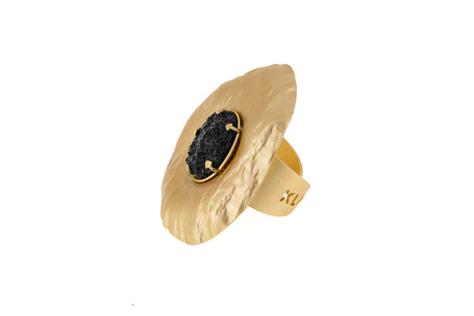 Sun Resin Ring in matt gold with black resin centre, angled side view showing the adjustable brass band and sculptural disc shape on white background