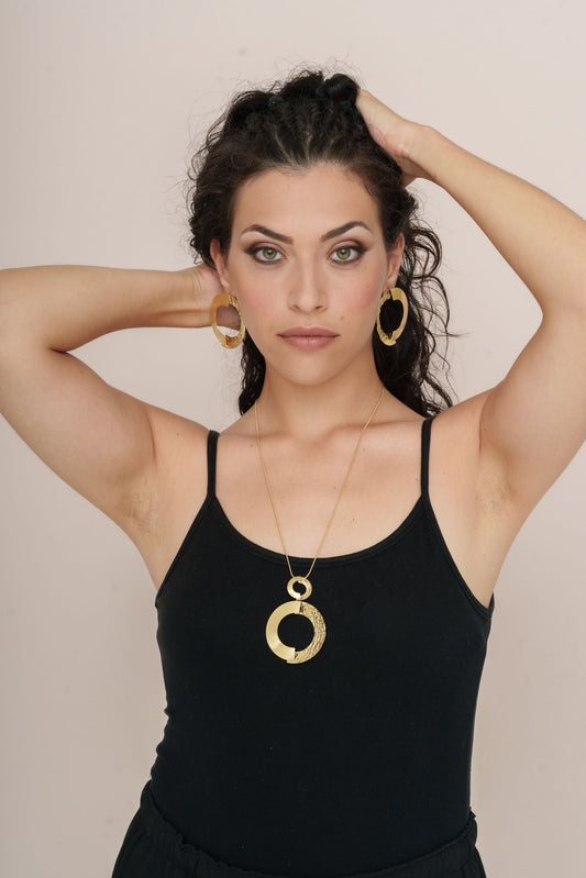 Model wearing the Large Textured Gold Semi-Circle Brass Earrings with matching Long Semicircle Necklace, styled with a black sleeveless top against a neutral background