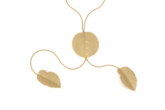 Matt Gold Brass Leaf Necklace product shot showing a large round leaf pendant threaded on a fine gold chain with two smaller leaf pendants cascading from each end, on white background