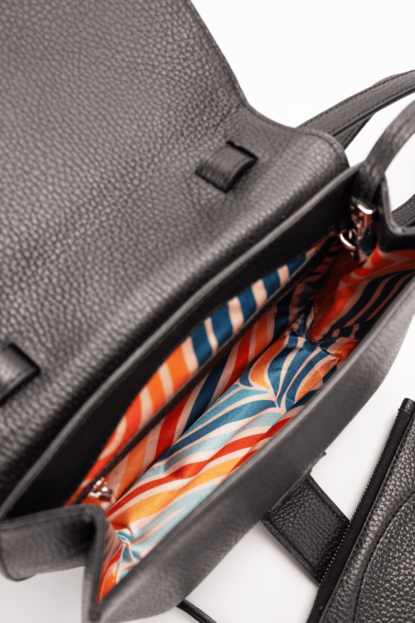 Yara Crossbody Bag in Black Italian Pebble Calf Leather - Interior Compartment Detail focusing on the colourful geometric lining.