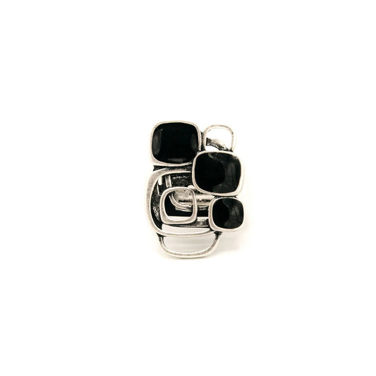 Geometric black resin and silver ring against a white background.