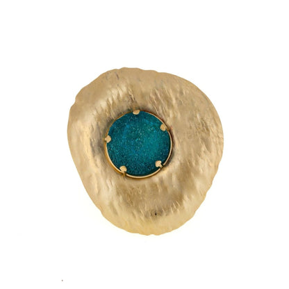 A textured gold ring with a central round turquoise-blue stone, photographed on a solid white background.
