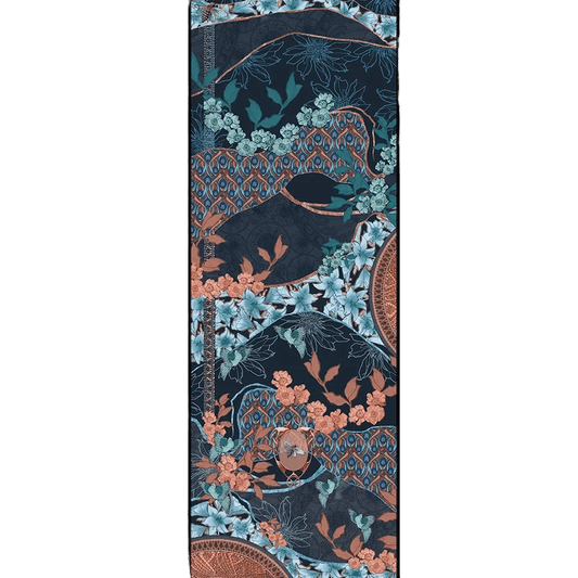 Lys Indigo cashmere and silk scarf print shown flat, with pale blue lilies, mint and coral blossoms, small turquoise birds and a bee in a copper oval medallion on rolling deep indigo hills edged in copper, with coral and blue peacock-feather bands.
