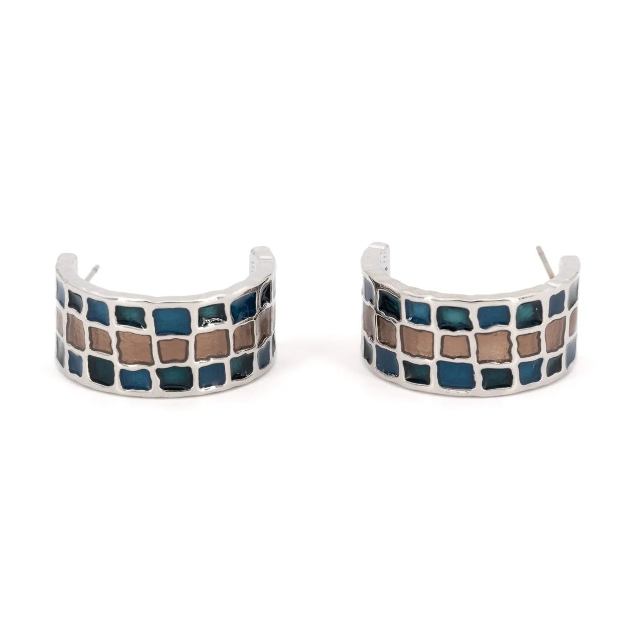 A pair of silver-toned huggie hoop earrings featuring a mosaic pattern of blue and brown square tiles, shown on a plain white background.