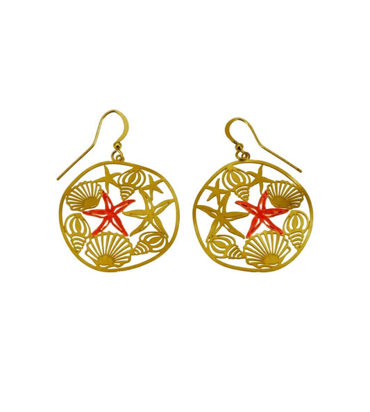 A pair of gold-tone dangle earrings with a circular openwork design featuring seashell and starfish motifs, accented with a coral-red starfish in the center, shown on a plain white background.